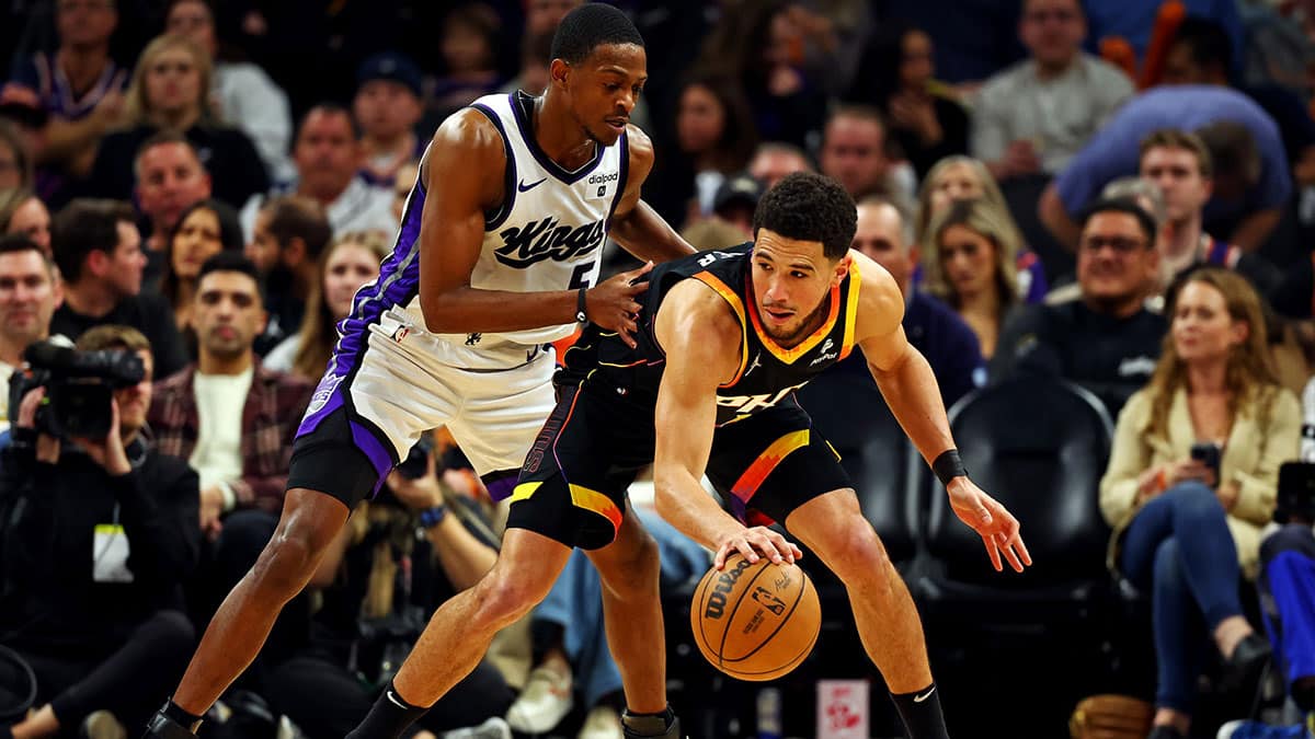 Phoenix Suns guard Devin Booker (1) handles the ball against Sacramento Kings guard De'Aaron Fox (5) during the third quarter at Footprint Center. 