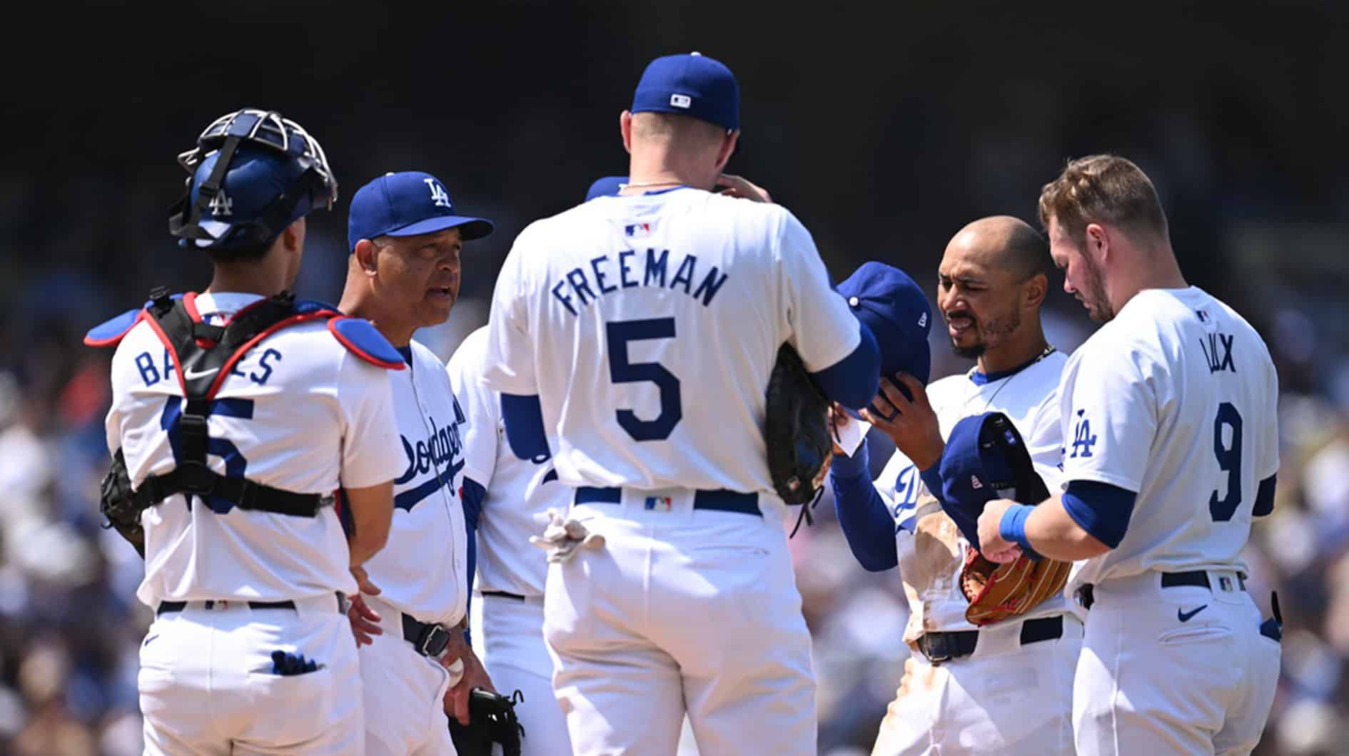 Los Angeles Dodgers manager Dave Roberts (30) meets at the mound with first baseman Freddie Freeman (5), shortstop Mookie Betts (50), catcher Austin Barnes (15), and second baseman Gavin Lux (9) against the New York Mets during the fourth inning at Dodger Stadium.