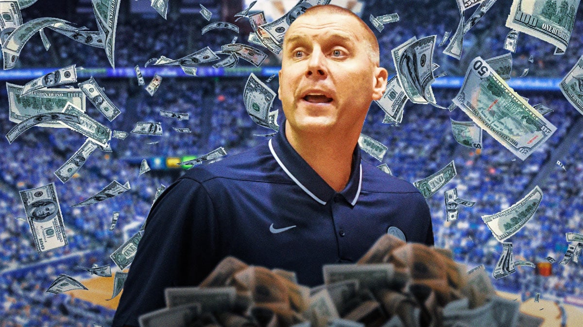 Mark Pope holding up bags of money