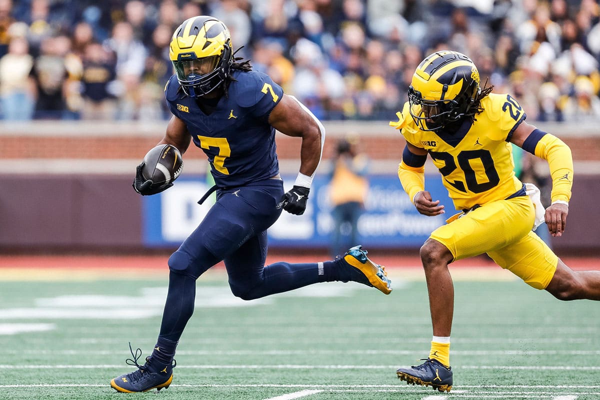 Blue Team running back Donovan Edwards (7) runs against Maize Team defensive back Jyaire Hill (20) during the first half of the spring game at Michigan Stadium