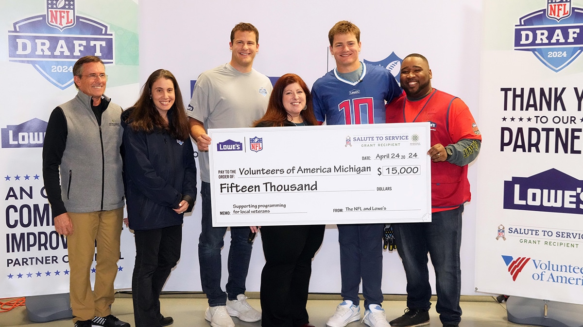 From left: Bob Woodruff Foundation co-founder Dave Woodruff, NFL Senior vice president of social responsibility Anna Isaacson, Detroit Lions tight end Sam LaPorta, Volunteers of America Michigan president Aubrey Macfarlane, North Carolina Tar Heels quarterback Drake Maye, and Lowe's store manager Amon Quickley pose with a $15,000 check to Volunteers of America Michigan.