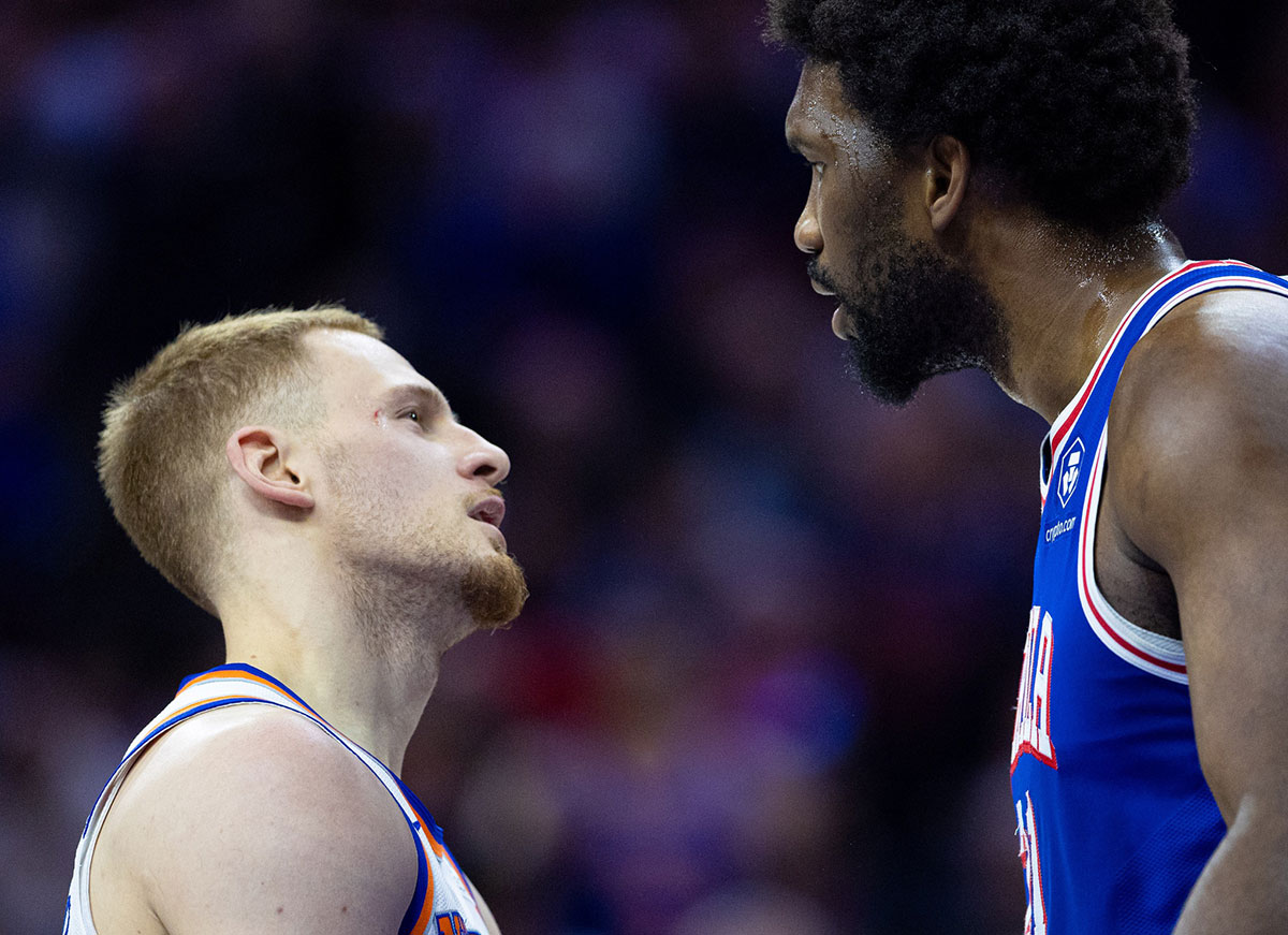 Philadelphia 76ers center Joel Embiid (21) has words with New York Knicks guard Donte DiVincenzo (L) after a play during the first quarter of game three of the first round for the 2024 NBA playoffs at Wells Fargo Center