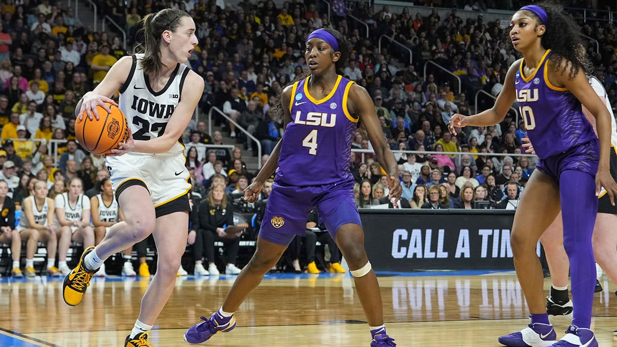 Iowa Hawkeyes guard Caitlin Clark (22) controls the ball against LSU Lady Tigers guard Flau'jae Johnson (4) and LSU Lady Tigers forward Angel Reese (10) in the third quarter in the finals of the Albany Regional in the 2024 NCAA Tournament 