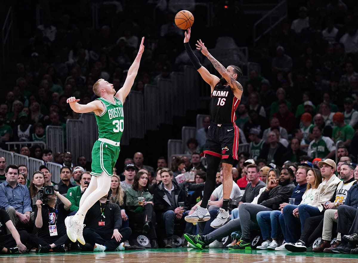 Miami Heat forward Caleb Martin (16) shoots for three points against Boston Celtics forward Sam Hauser (30) in the second quarter during game two of the first round for the 2024 NBA playoffs at TD Garden.