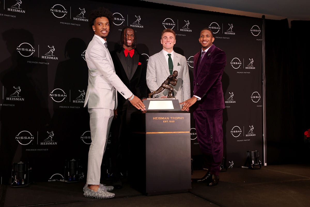Heisman hopefuls (left to right) LSU Tigers quarterback Jayden Daniels and Ohio State Buckeyes wide receiver Marvin Harrison Jr. and Oregon Ducks quarterback Bo Nix and Washington Huskies quarterback Michael Penix Jr. pose with the Heisman trophy during a press conference in the Astor ballroom at the New York Marriott Marquis before the presentation of the Heisman trophy. 