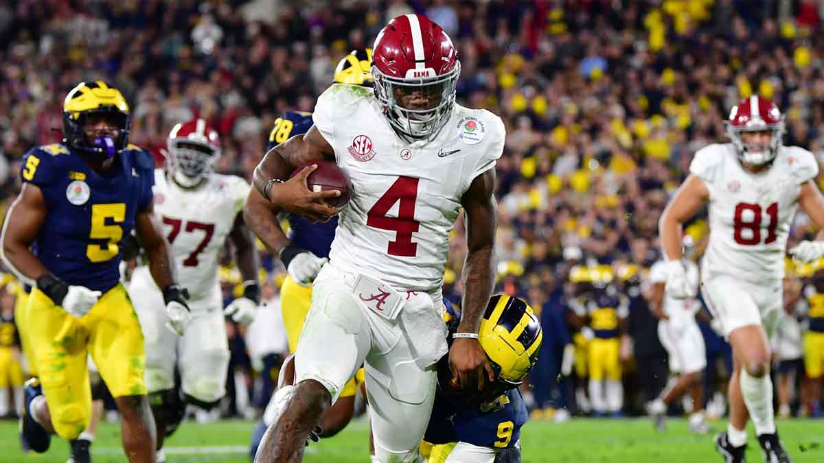 Alabama Crimson Tide quarterback Jalen Milroe (4) runs against Michigan Wolverines defensive back Rod Moore (9) in overtime in the 2024 Rose Bowl college football playoff semifinal game at Rose Bowl.