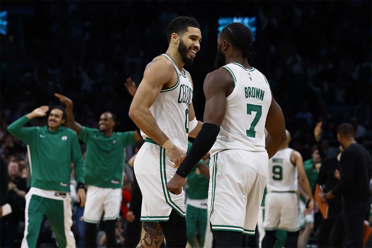 Boston Celtics forward Jayson Tatum (0) and guard Jaylen Brown (7) celebrate during overtime of their 127-120 win over the Minnesota Timberwolves at TD Garden.