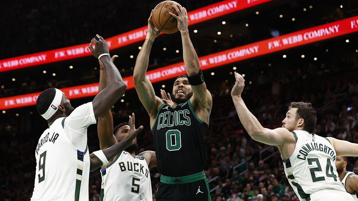 Boston Celtics forward Jayson Tatum (0) goes to the basket between Milwaukee Bucks guard Pat Connaughton (24) and forward Bobby Portis (9) during the second half at TD Garden.