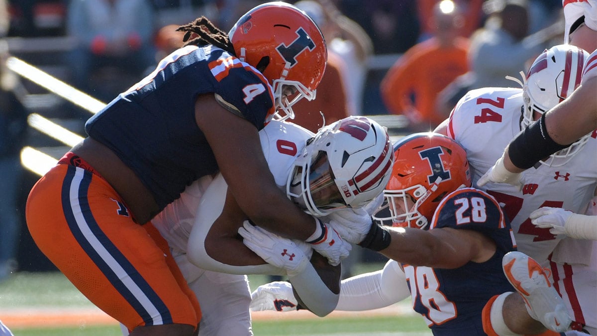 Illinois Fighting Illini defensive tackle Jer'Zhan Newton (4) tackles Wisconsin Badgers running back Braelon Allen (0) during the first half at Memorial Stadium