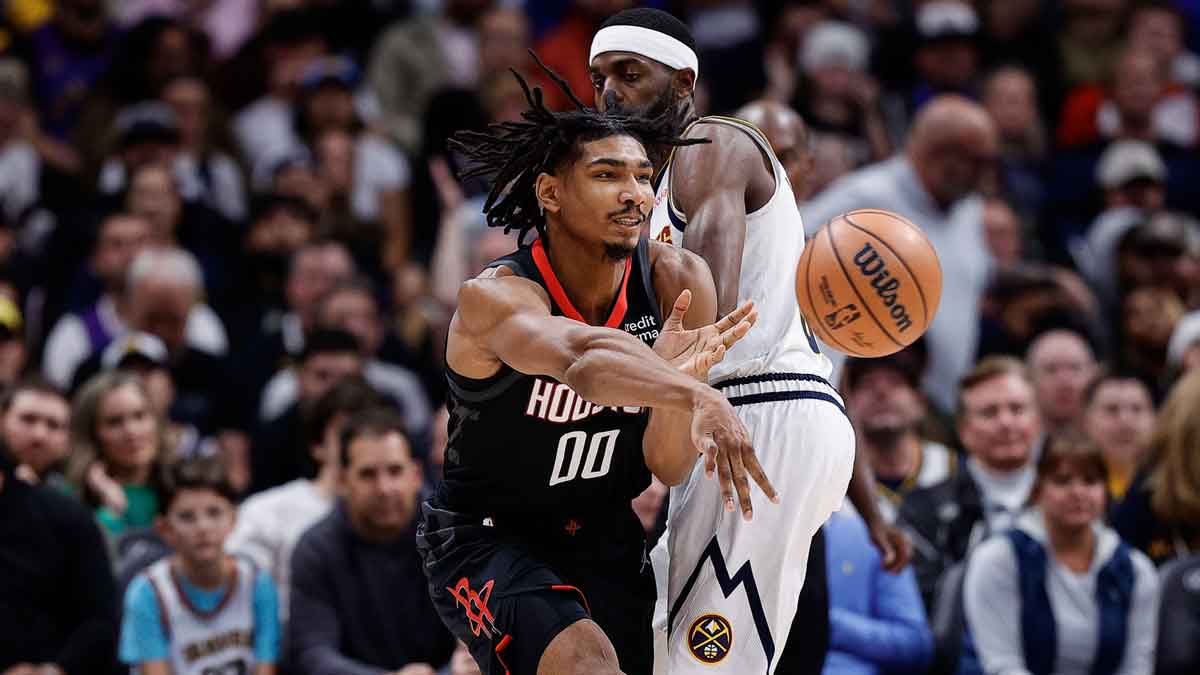 Houston Rockets forward Jermaine Samuels Jr. (00) passes the ball as Denver Nuggets forward Justin Holiday (9) defends in the fourth quarter at Ball Arena.
