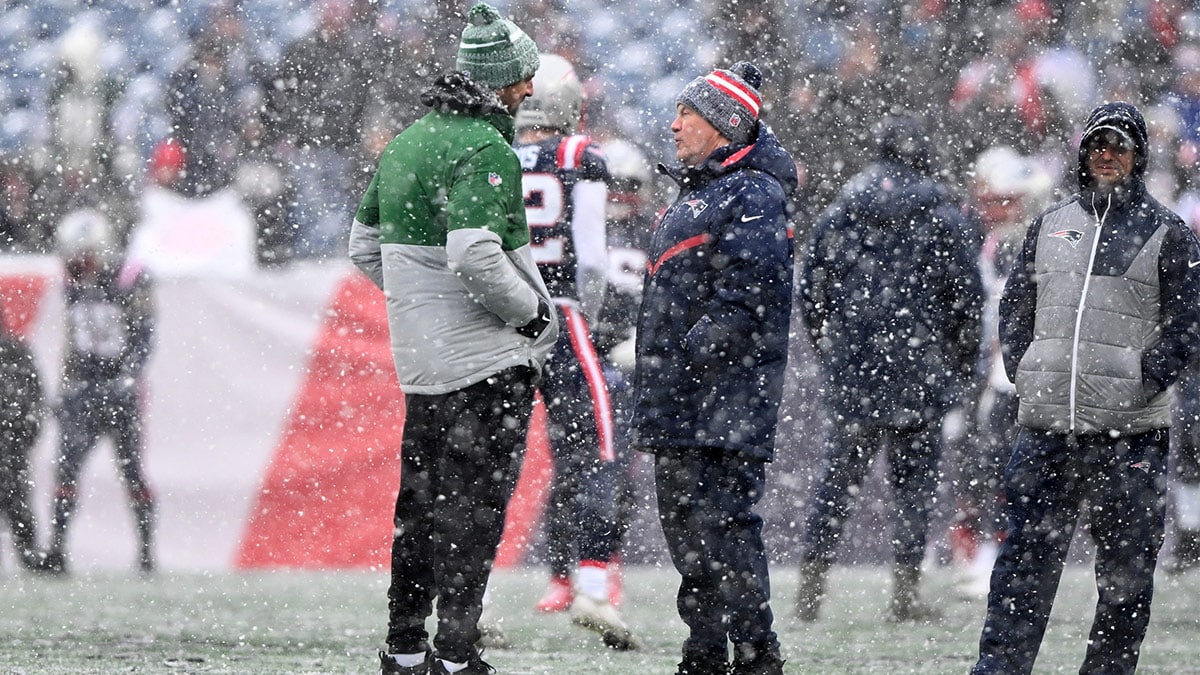 New York Jets quarterback Aaron Rodgers (8) talks with New England Patriots head coach Bill Belichick before a game at Gillette Stadium.