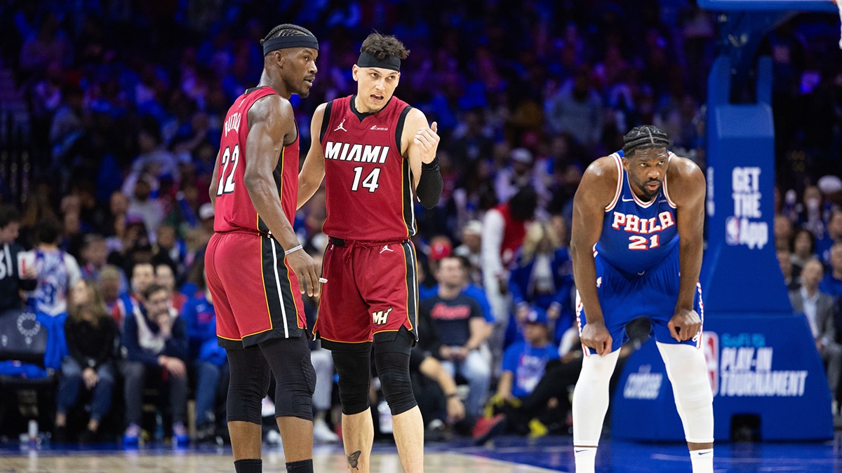 Miami Heat forward Jimmy Butler (22) and guard Tyler Herro (14) talk as Philadelphia 76ers center Joel Embiid (21) stands behind during the third quarter of a play-in game of the 2024 NBA playoffs at Wells Fargo Center. 