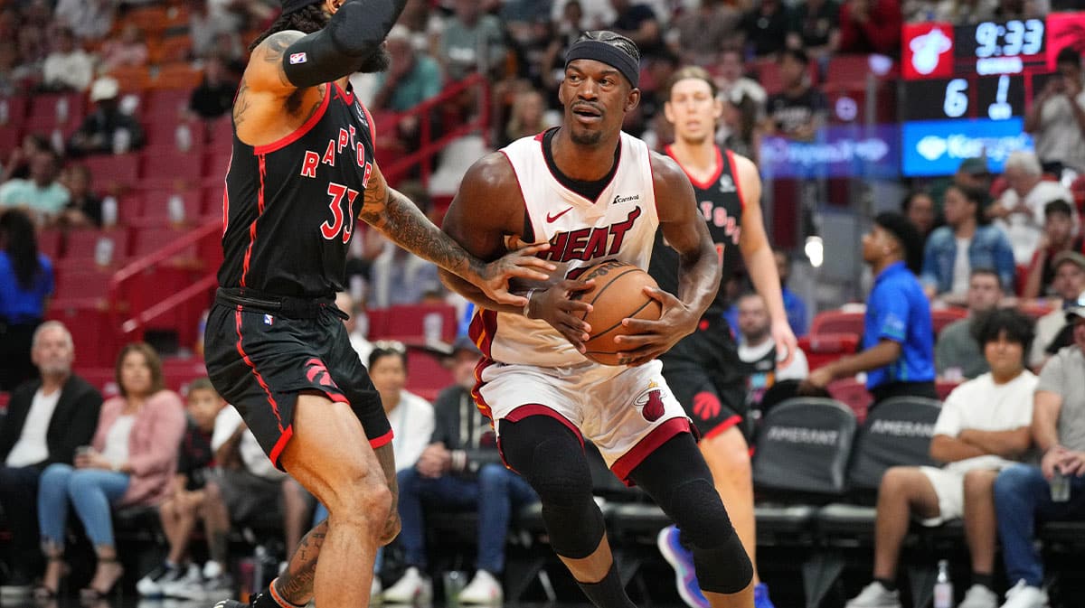 Miami Heat forward Jimmy Butler (22) brings the ball up the court as Toronto Raptors guard Gary Trent Jr. (33) defends during the first half at Kaseya Center.