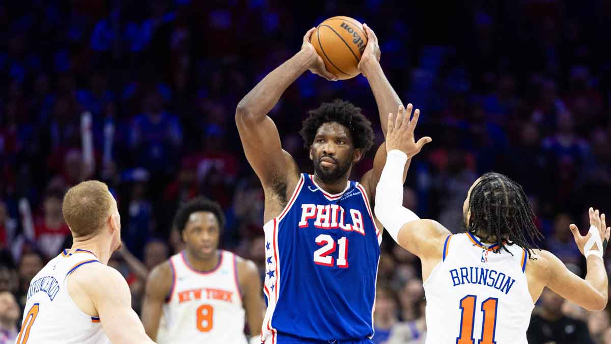 76ers center Joel Embiid (21) controls the ball in front of New York Knicks guard Jalen Brunson (11) and guard Donte DiVincenzo (0) during the second half of game three of the first round for the 2024 NBA playoffs at Wells Fargo Center.