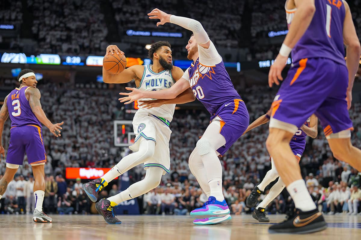 Minnesota Timberwolves center Karl-Anthony Towns (32) dribbles against Phoenix Suns center Jusuf Nurkic (20) in the fourth quarter during game two of the first round for the 2024 NBA playoffs at Target Center.
