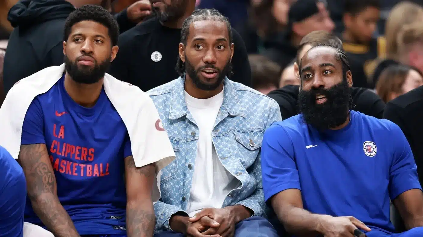 Los Angeles Clippers forward Paul George (13, left) and forward Kawhi Leonard (2, center) and guard James Harden (1, right) watch the game from the bench during the third quarter against the Utah Jazz at Crypto.com Arena.