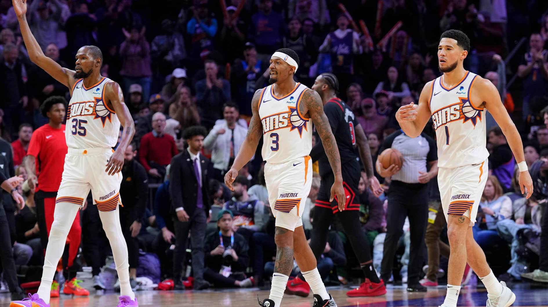 Phoenix Suns forward Kevin Durant (35) and Phoenix Suns guard Bradley Beal (3) and Phoenix Suns guard Devin Booker (1) reacts during the second half of the game against the Chicago Bulls at Footprint Center.