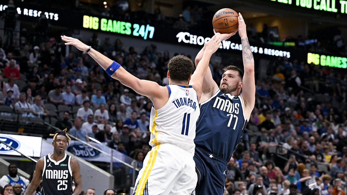 Dallas Mavericks guard Luka Doncic (77) shoots over Golden State Warriors guard Klay Thompson (11) during the second half at the American Airlines Center.