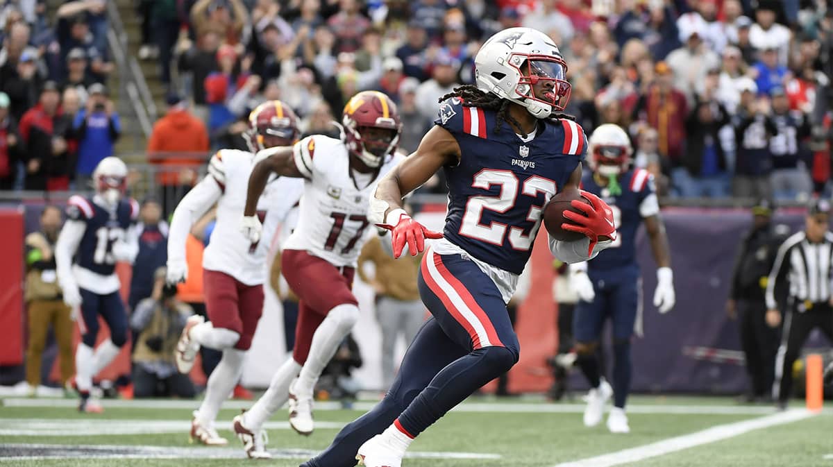 New England Patriots safety Kyle Dugger (23) runs the ball out of the end zone after an interception during the first half against the Washington Commanders at Gillette Stadium.