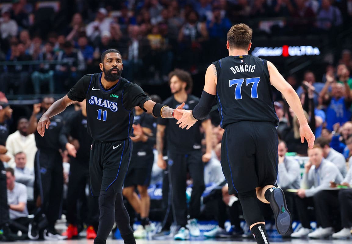 Dallas Mavericks guard Kyrie Irving (11) celebrates with Dallas Mavericks guard Luka Doncic (77) during the first half against the Utah Jazz at American Airlines Center.