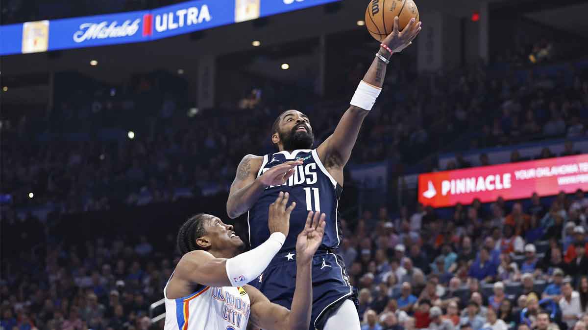 Dallas Mavericks guard Kyrie Irving (11) goes up for a basket beside Oklahoma City Thunder forward Jalen Williams (8) during the first half at Paycom Center.
