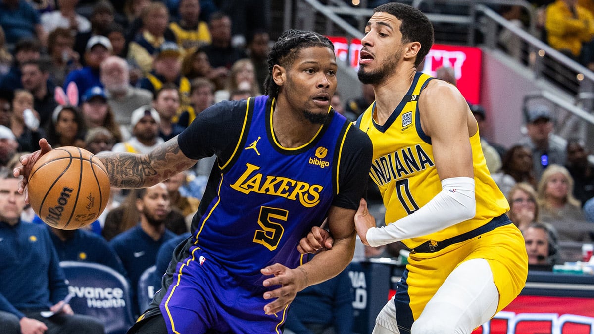 Los Angeles Lakers forward Cam Reddish (5) dribbles the ball while Indiana Pacers guard Tyrese Haliburton (0) defends in the second half at Gainbridge Fieldhouse.
