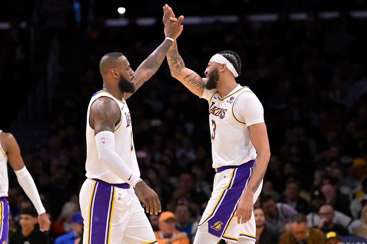 Los Angeles Lakers forward LeBron James (23) and forward Anthony Davis (3) high-five after a play in the first half against the Indiana Pacers at Crypto.com Arena.