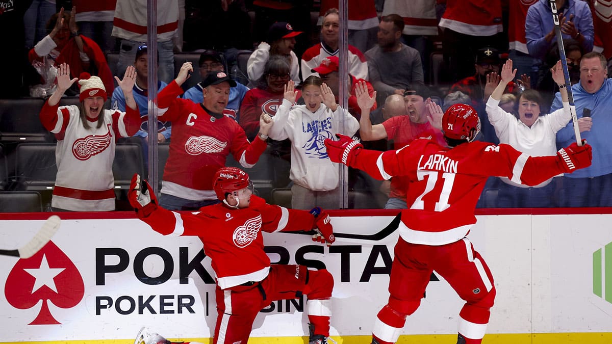 Detroit Red Wings left wing Lucas Raymond (23) celebrates with center Dylan Larkin (71) after he scores in overtime against the Montreal Canadiens at Little Caesars Arena.