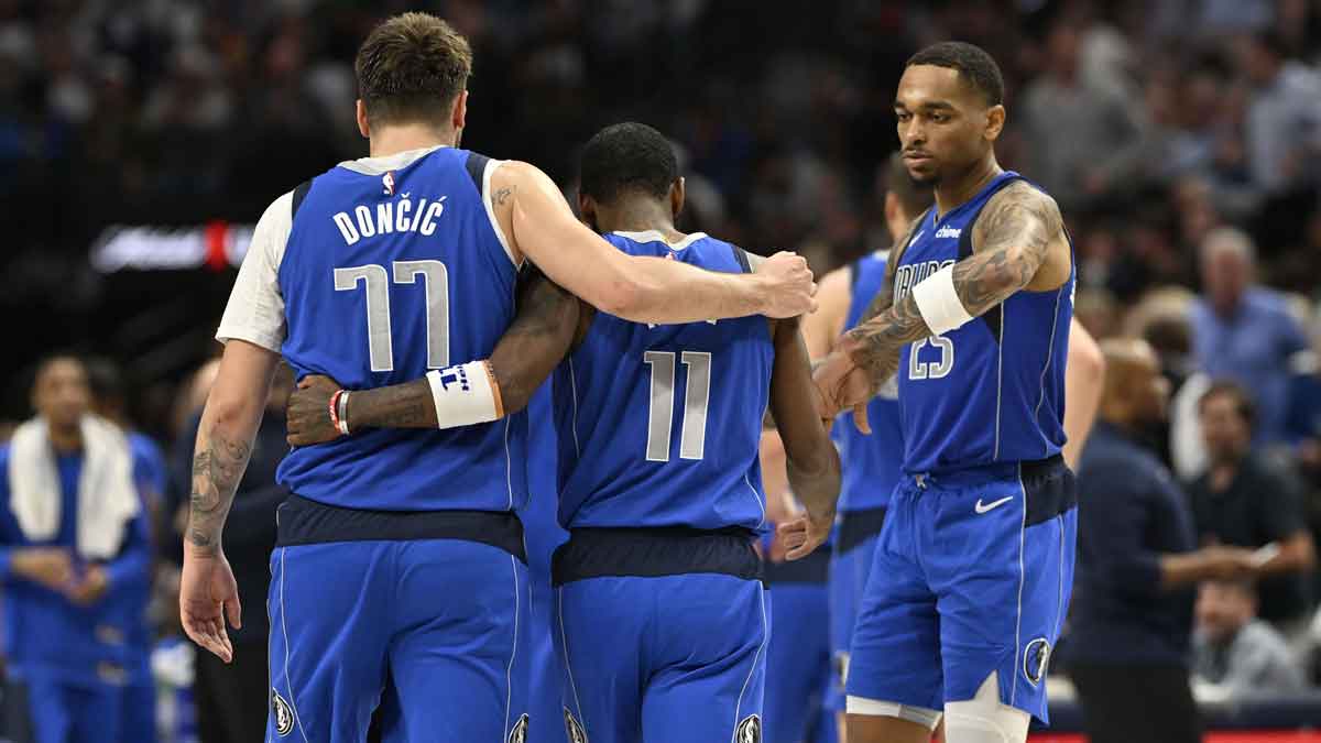 Dallas Mavericks guard Luka Doncic (77) and guard Kyrie Irving (11) and forward P.J. Washington (25) walk off the court during the first half at the American Airlines Center.