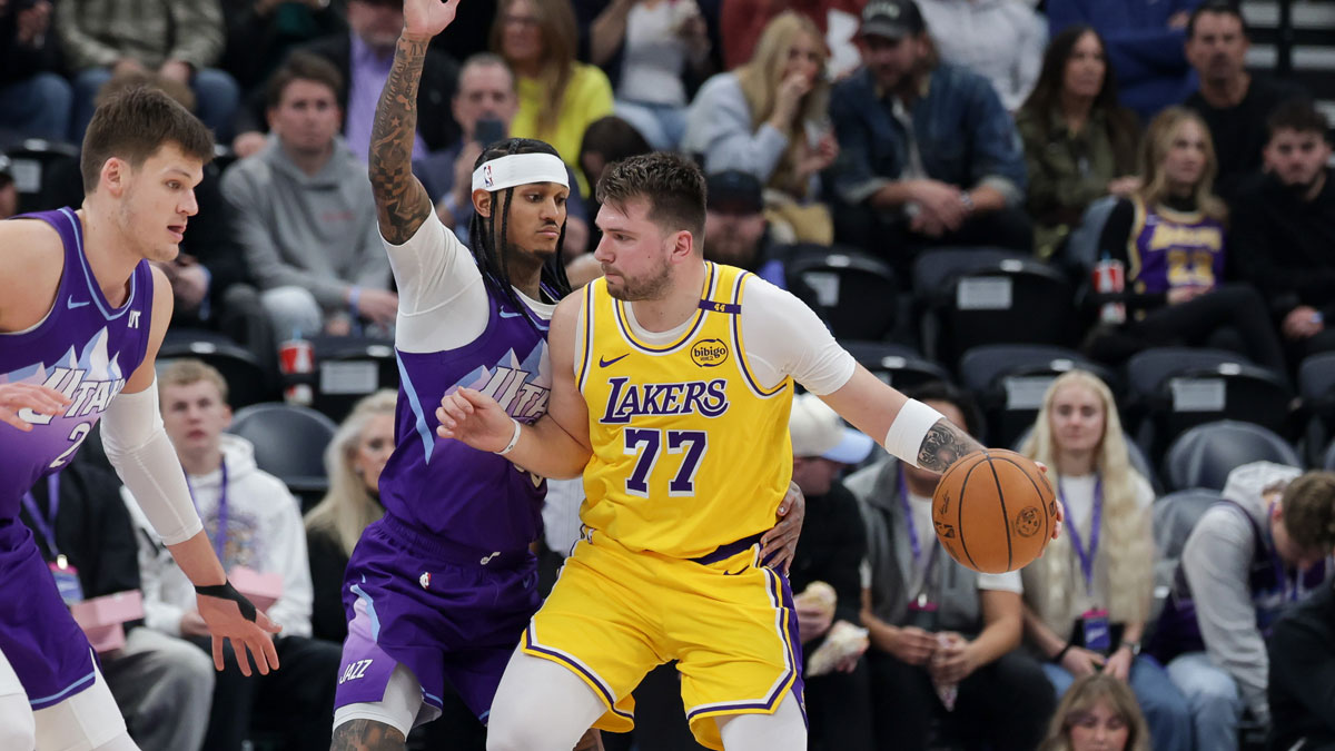 Los Angeles Lakers guard Luka Doncic (77) dribbles against Utah Jazz guard Jordan Clarkson (00) during the second half at Delta Center.