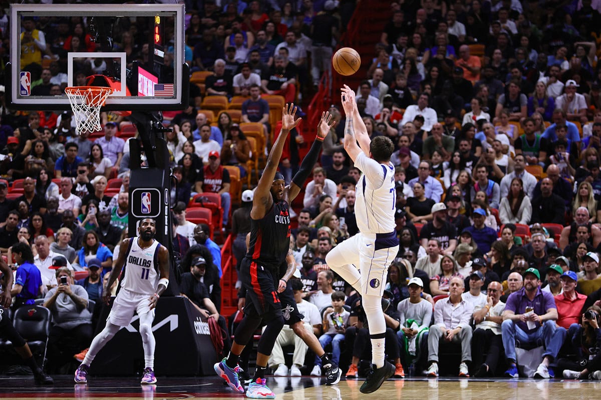 Dallas Mavericks guard Luka Doncic (77) shoots the ball over Miami Heat center Bam Adebayo (13) during the second quarter at Kaseya Center. 