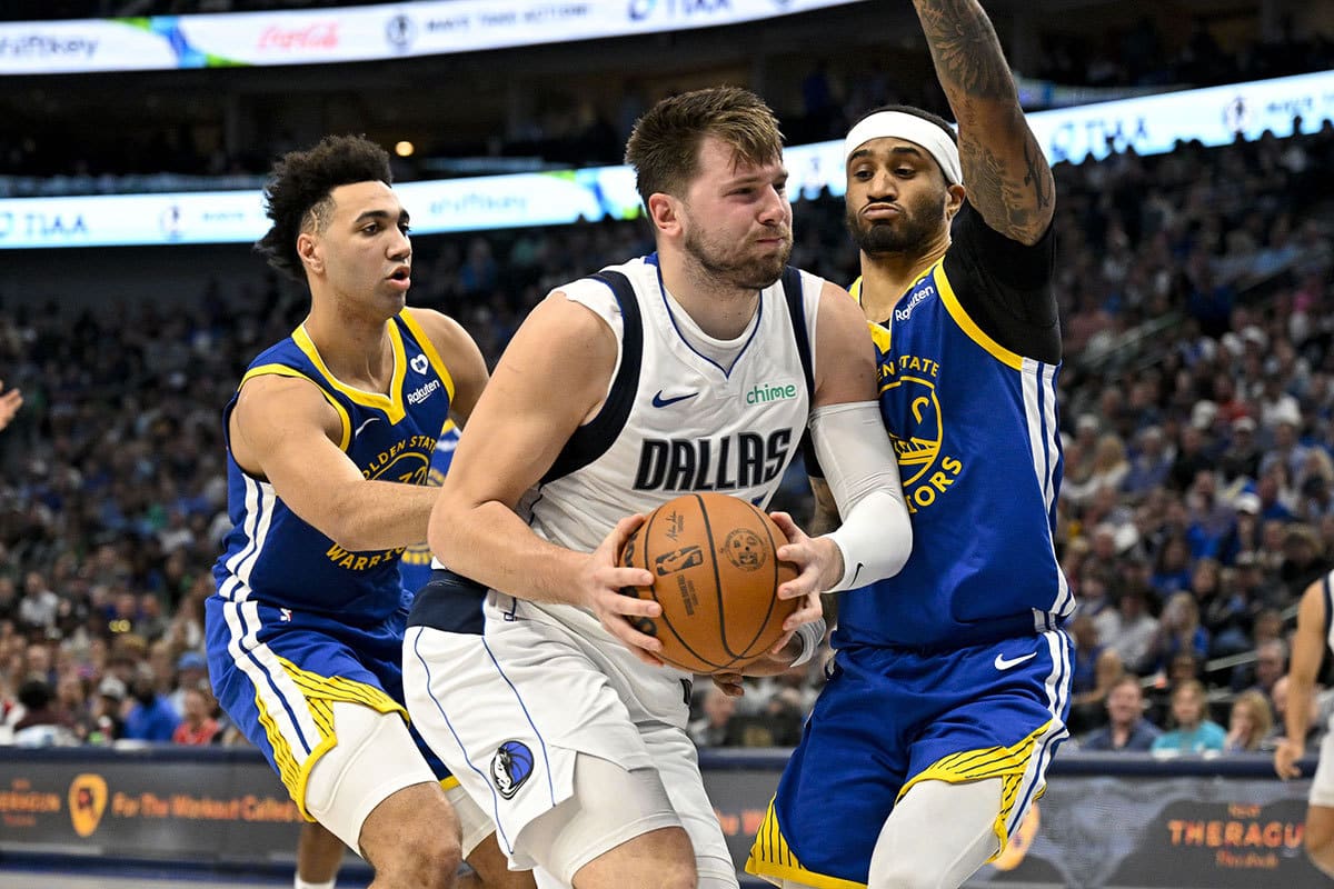 Dallas Mavericks guard Luka Doncic (77) drives to the basket past Golden State Warriors forward Trayce Jackson-Davis (32) and guard Gary Payton II (0) during the first half at the American Airlines Center. 