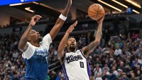 Sacramento Kings guard Malik Monk (0) goes to the basket as Minnesota Timberwolves center Naz Reid (11) defends during the second quarter at Target Center.