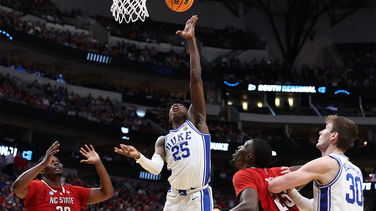Duke Blue Devils forward Mark Mitchell (25) shoots against North Carolina State Wolfpack forward Mohamed Diarra (23) and forward DJ Burns Jr. (30) in the second half in the finals of the South Regional of the 2024 NCAA Tournament at American Airline Center.