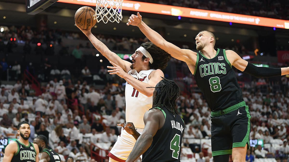 Apr 29, 2024; Miami, Florida, USA; Miami Heat guard Jaime Jaquez Jr. (11) scores in front of Boston Celtics center Kristaps Porzingis (8) during the first quarter of game four of the first round for the 2024 NBA playoffs at Kaseya Center. Mandatory Credit: Michael Laughlin-USA TODAY Sports
