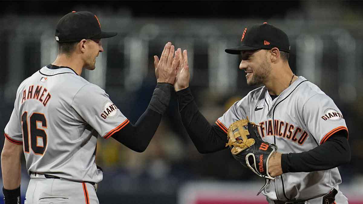 San Francisco Giants left fielder Michael Conforto (8) congratulates shortstop Nick Ahmed (16) after defeating the San Diego Padres at Petco Park.
