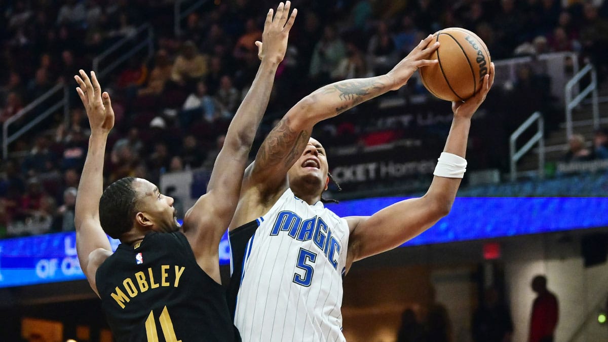 Dec 6, 2023; Cleveland, Ohio, USA; Orlando Magic forward Paolo Banchero (5) drives to the basket against Cleveland Cavaliers forward Evan Mobley (4) during the first half at Rocket Mortgage FieldHouse.