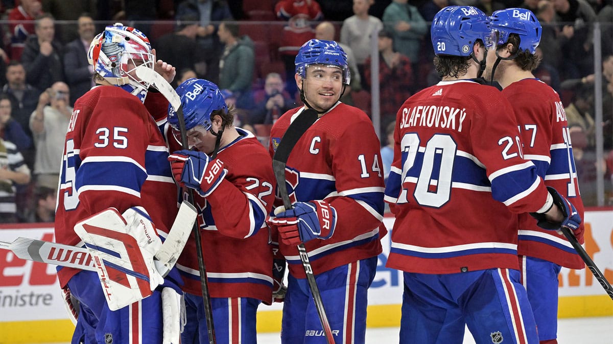 Montreal Canadiens goalie Sam Montembeault (35) celebrates the win against the Florida Panthers with teammates forward Cole Caufield (22) and forward Nick Suzuki (14) and forward Juraj Slafkovsky (20) at the Bell Centre.