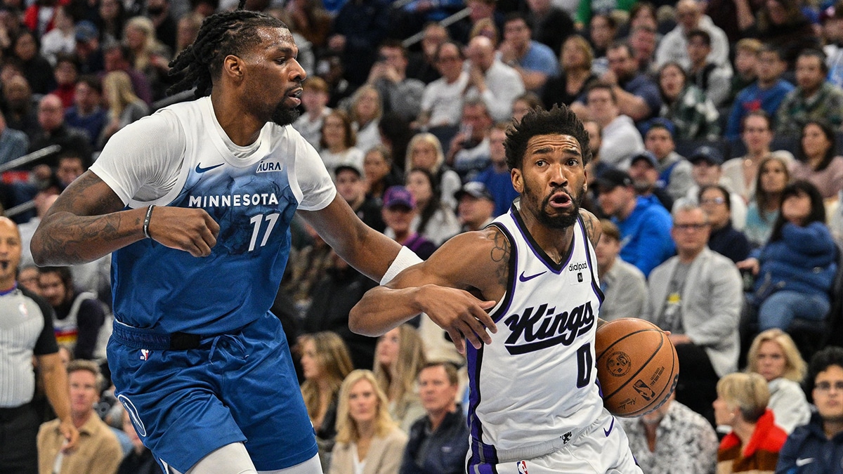 Sacramento Kings guard Malik Monk (0) goes to the basket as Minnesota Timberwolves center Naz Reid (11) defends during the game at Target Cente