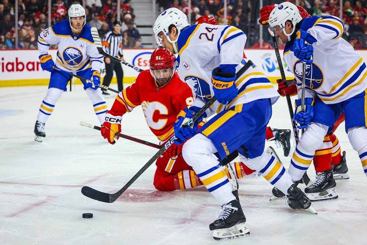 Calgary Flames center Nazem Kadri (91) and Buffalo Sabres center Dylan Cozens (24) battles for the puck during the second period at Scotiabank Saddledome.