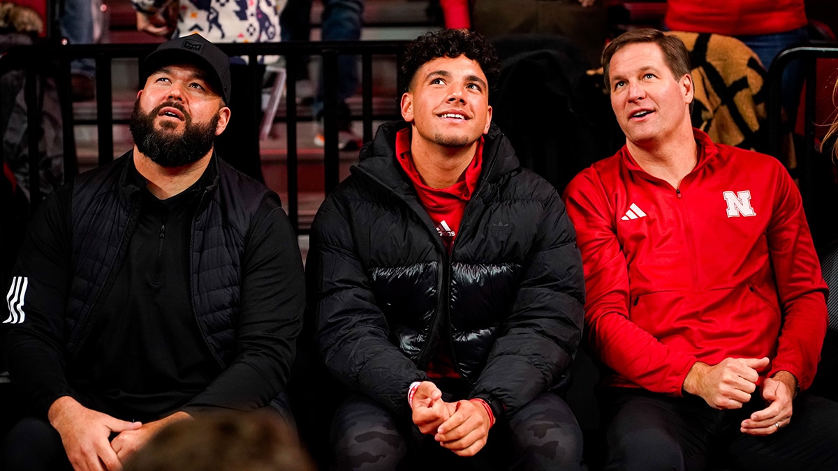 Jan 3, 2024; Lincoln, Nebraska, USA; Nebraska Cornhuskers football assistant coach Donovan Raiola (left), Dylan Raiola (center) and athletic director Trev Alberts sit courtside before the game against the Indiana Hoosiers at Pinnacle Bank Arena. Dylan is the top quarterback recruit in the 2024 class. Mandatory Credit: Dylan Widger-USA TODAY Sports