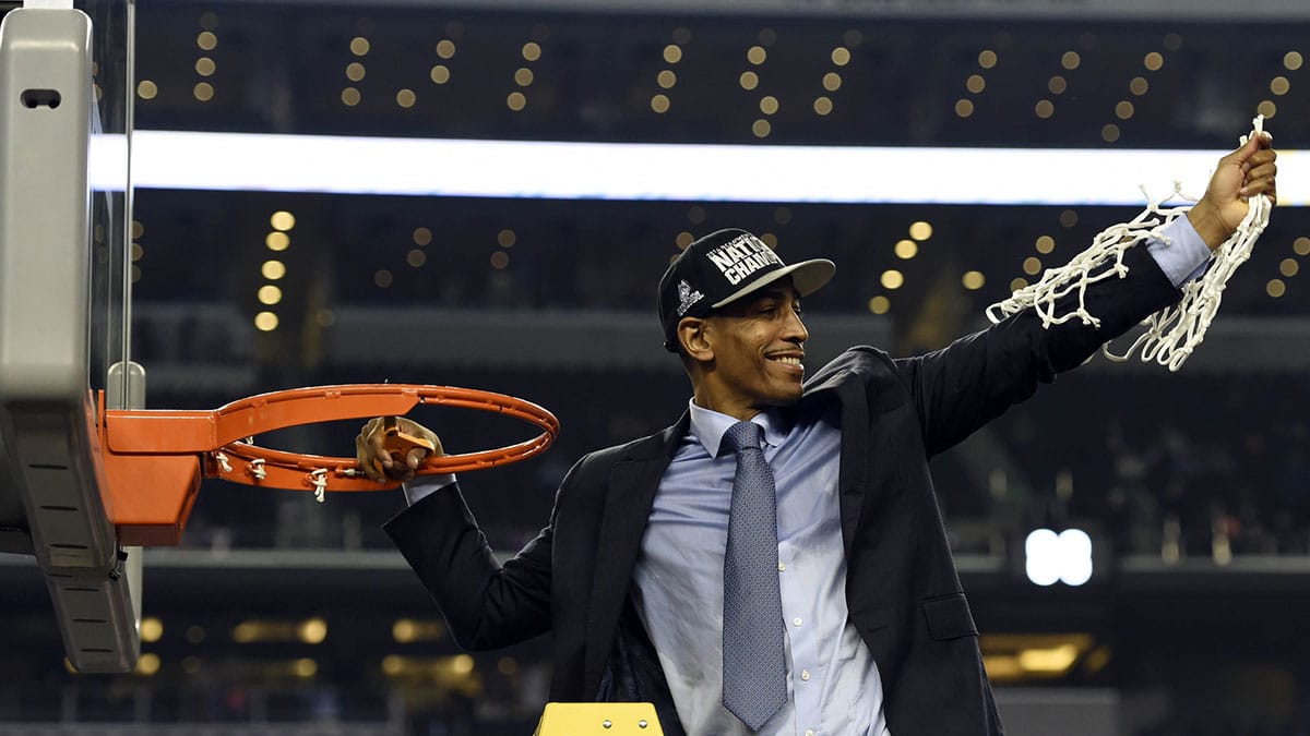 Connecticut Huskies head coach Kevin Ollie waves to fans after cutting down the net following the championship game of the Final Four in the 2014 NCAA Mens Division I Championship tournament against the Kentucky Wildcats at AT&T Stadium