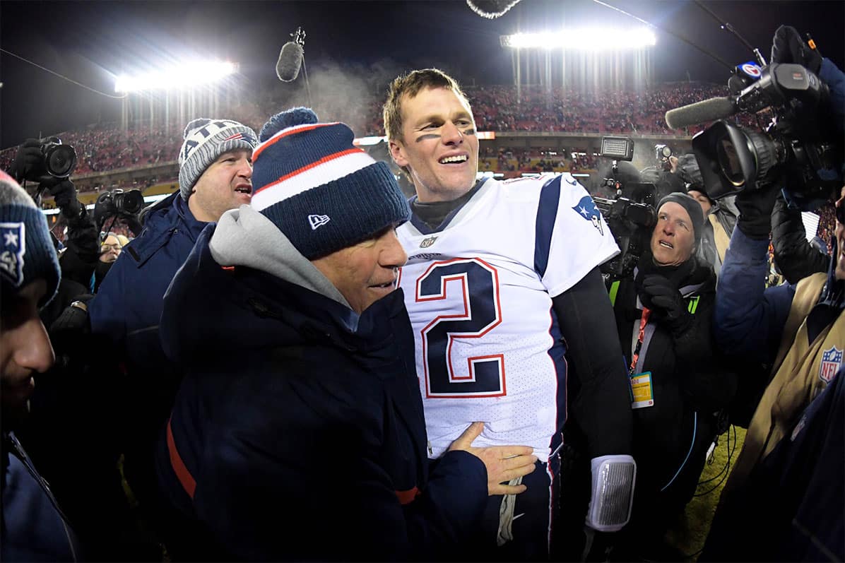 New England Patriots head coach Bill Belichick and quarterback Tom Brady (12) celebrate the win over the Kansas City Chiefs during overtime in the AFC Championship game at Arrowhead Stadium.