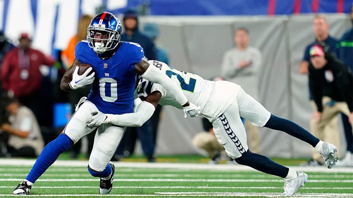 New York Giants wide receiver Parris Campbell (0) is tackled by Seattle Seahawks cornerback Devon Witherspoon (21) in the first half at MetLife Stadium 