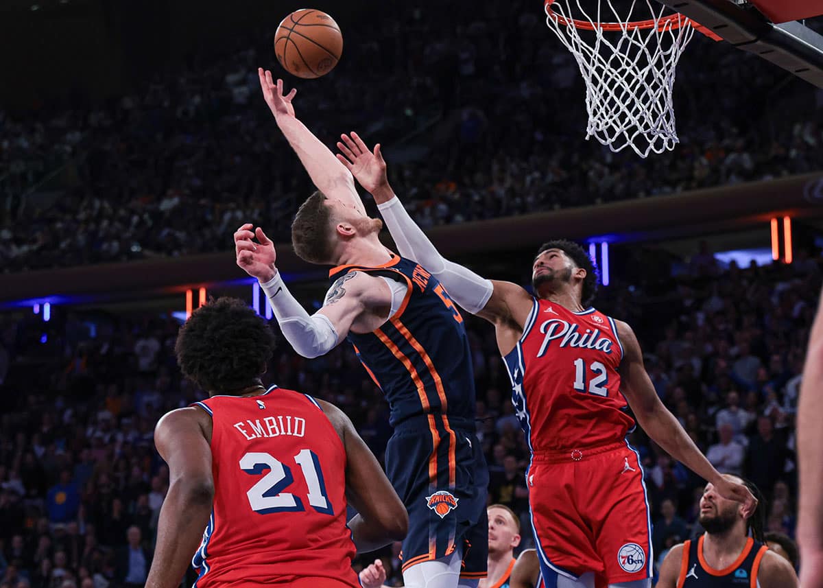 New York Knicks player Isaiah Hartenstein and Philadelphia 76ers player Tobias Harris try to get a rebound