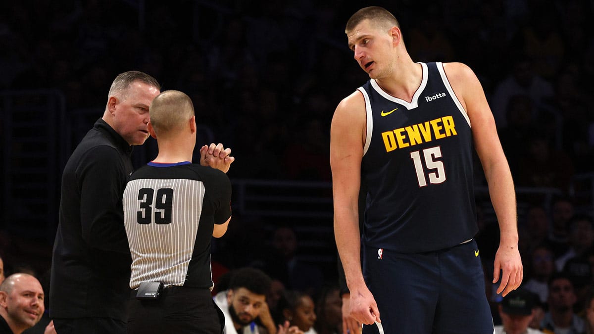 Denver Nuggets head coach Michael Malone and center Nikola Jokic (15) talk to referee Tyler Ford (39) during the third quarter in game four of the first round for the 2024 NBA playoffs against the Los Angeles Lakers at Crypto.com Arena.