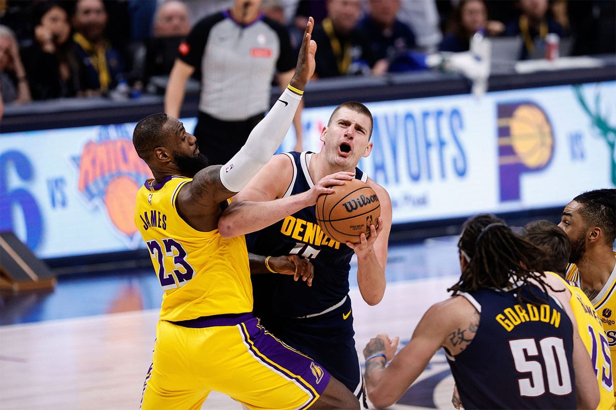 Denver Nuggets center Nikola Jokic (15) drives to the net against Los Angeles Lakers forward LeBron James (23) in the fourth quarter during game five of the first round for the 2024 NBA playoffs at Ball Arena.
