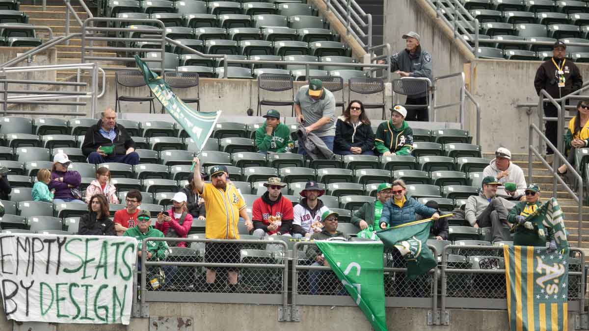 Oakland Athletics fans cheer on their team against the Boston Red Sox during the first inning at Oakland-Alameda County Coliseum.