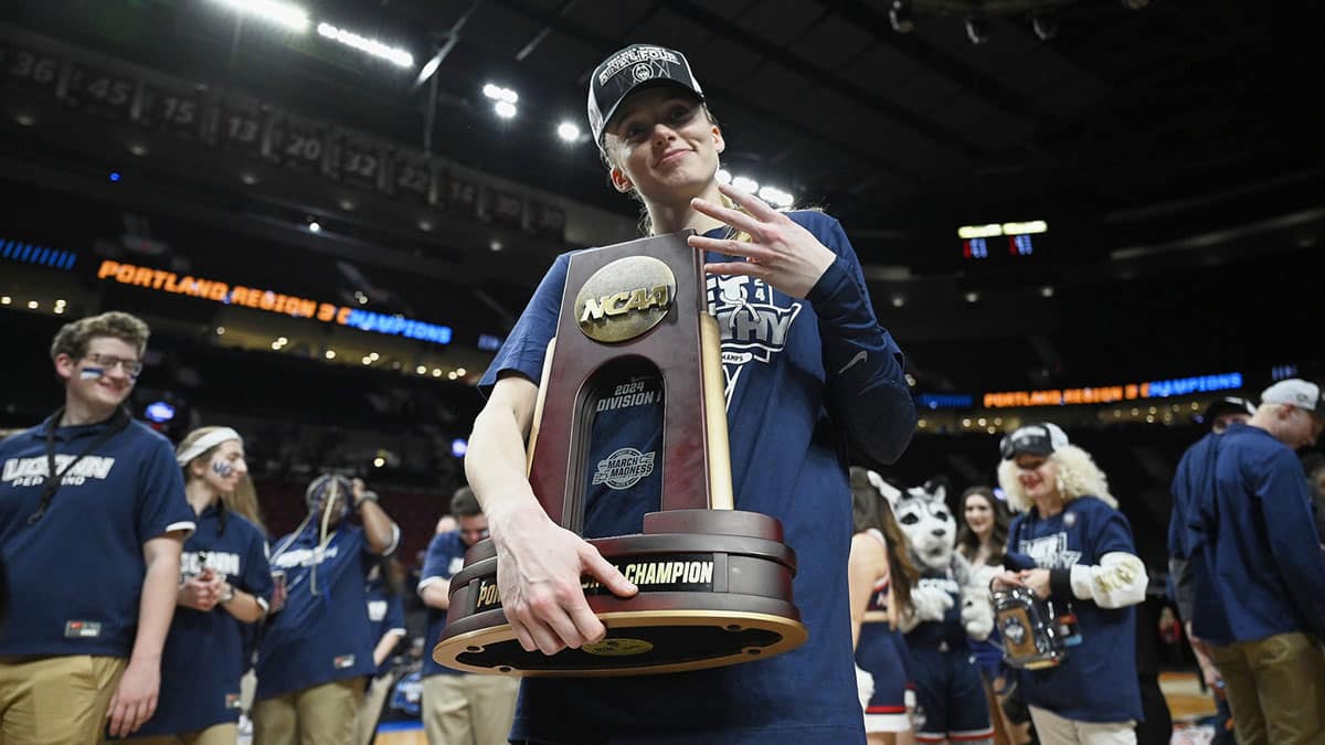 UConn Huskies guard Paige Bueckers (5) holds the championship trophy after beating the USC Trojans in the finals of the Portland Regional of the NCAA Tournament at the Moda Center.