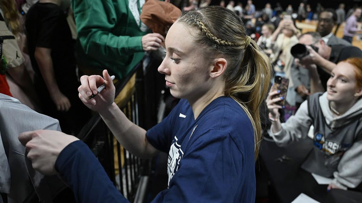 UConn Huskies guard Paige Bueckers (5) signs autographs for fans after a game against the USC Trojans in the finals of the Portland Regional of the NCAA Tournament.